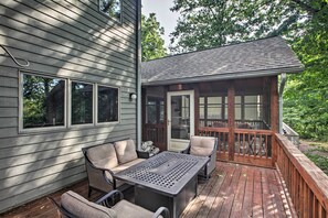 A wooden deck with a table and chairs, a covered porch, and a view of the surrounding trees. - Cozy Wintergreen Resort Escape Near Leaf Peeping! (Nellysford)