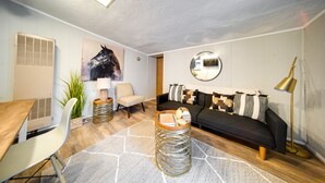 A modern living room with a sofa, coffee table, and a mounted mirror. - Pet-friendly Mayfield Heights Vacation Rental! (Mayfield Heights)