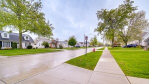 A suburban street with houses, a sidewalk, and a no parking sign. - Pet-friendly Mayfield Heights Vacation Rental! (Mayfield Heights)