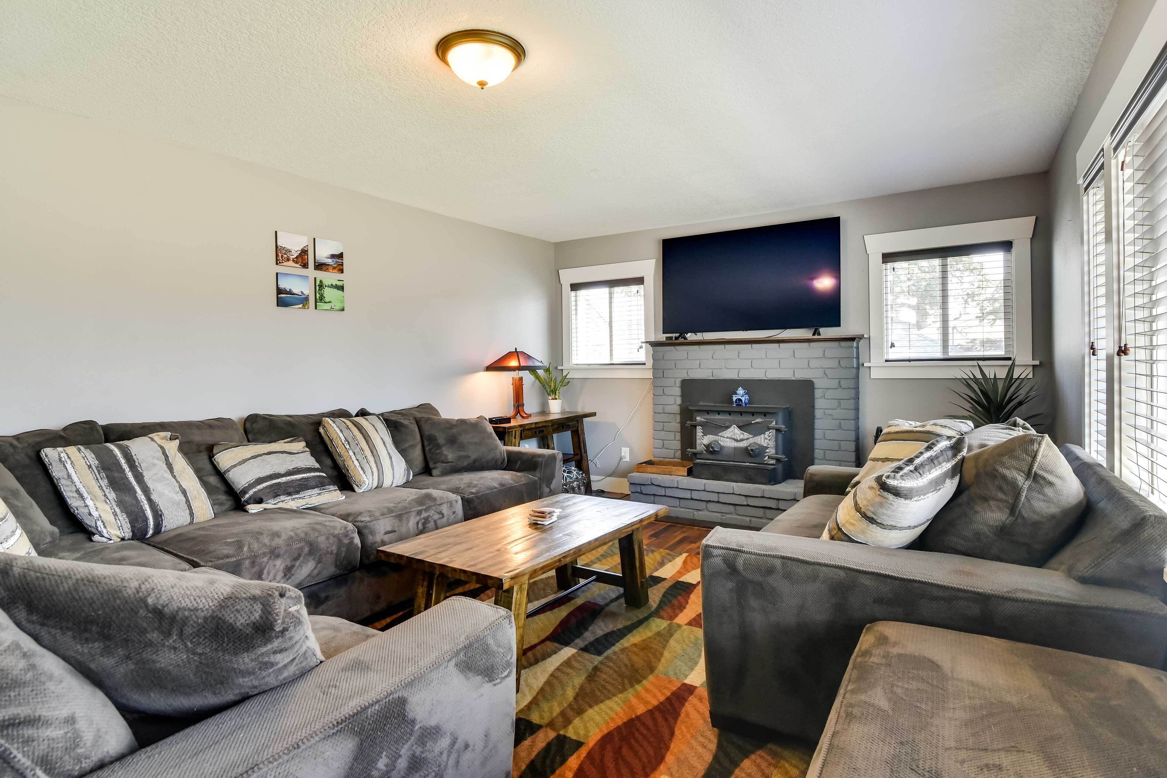 A living room with a sectional sofa, a coffee table, a fireplace, and a flat-screen TV.