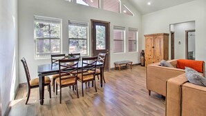Un vaste espace de vie comprenant une table et des chaises, un canapé et un meuble en bois.