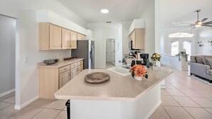 Una cocina moderna con una isla central, armarios de madera y un refrigerador empotrado.
