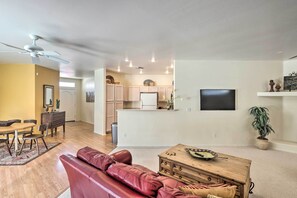 Ein modernes Wohnzimmer mit einem roten Ledersofa, einem Holztisch und einem Essbereich mit Holztable und Stühlen.