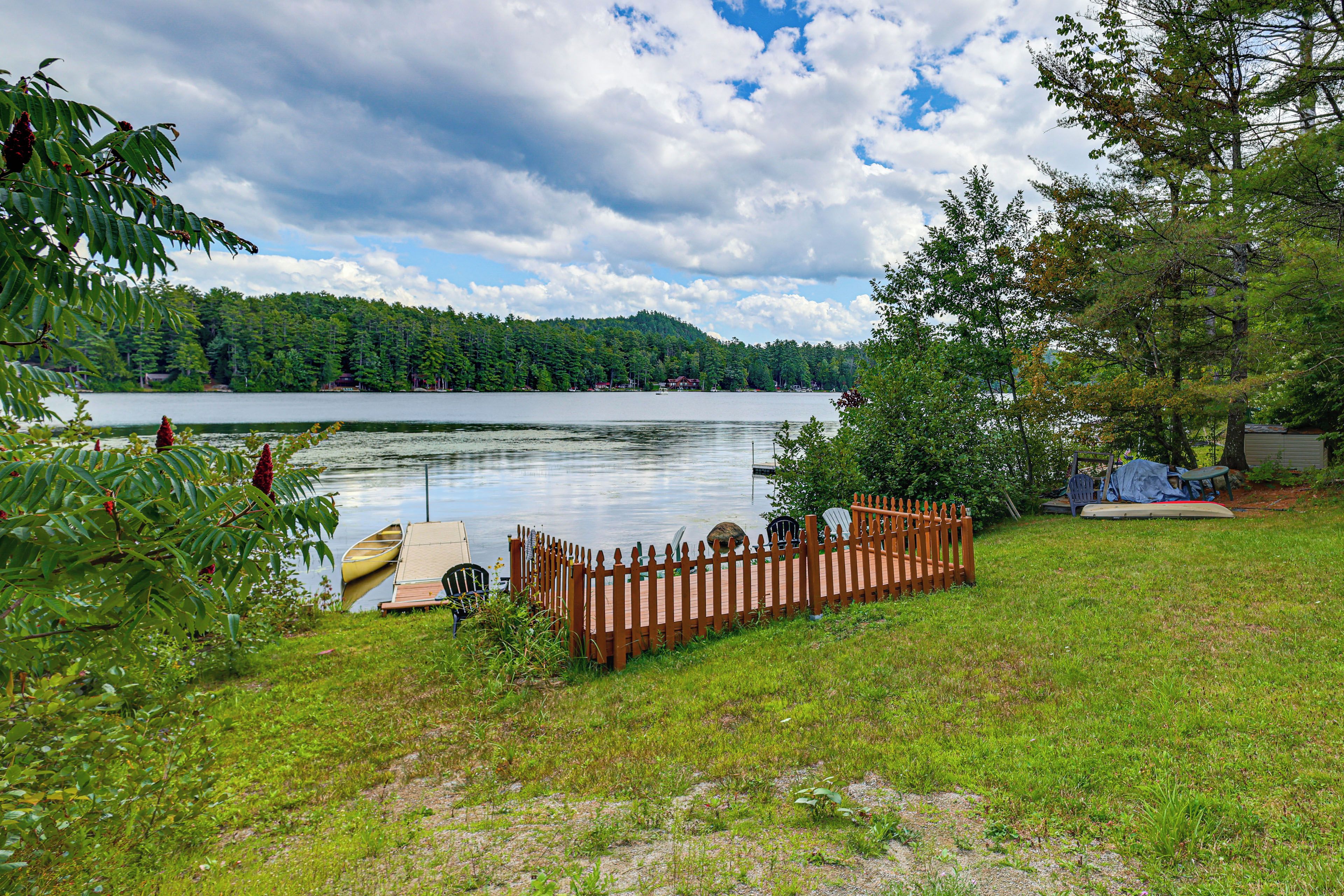 Une propriété au bord du lac, dotée d’un quai en bois, d’un espace clôturé et d’une tente.