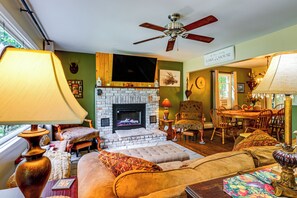 A cozy living room with a fireplace, comfortable seating, and a dining area. - Rustic Adirondacks Home w/ Hot Tub & Lake Access! (Chestertown)