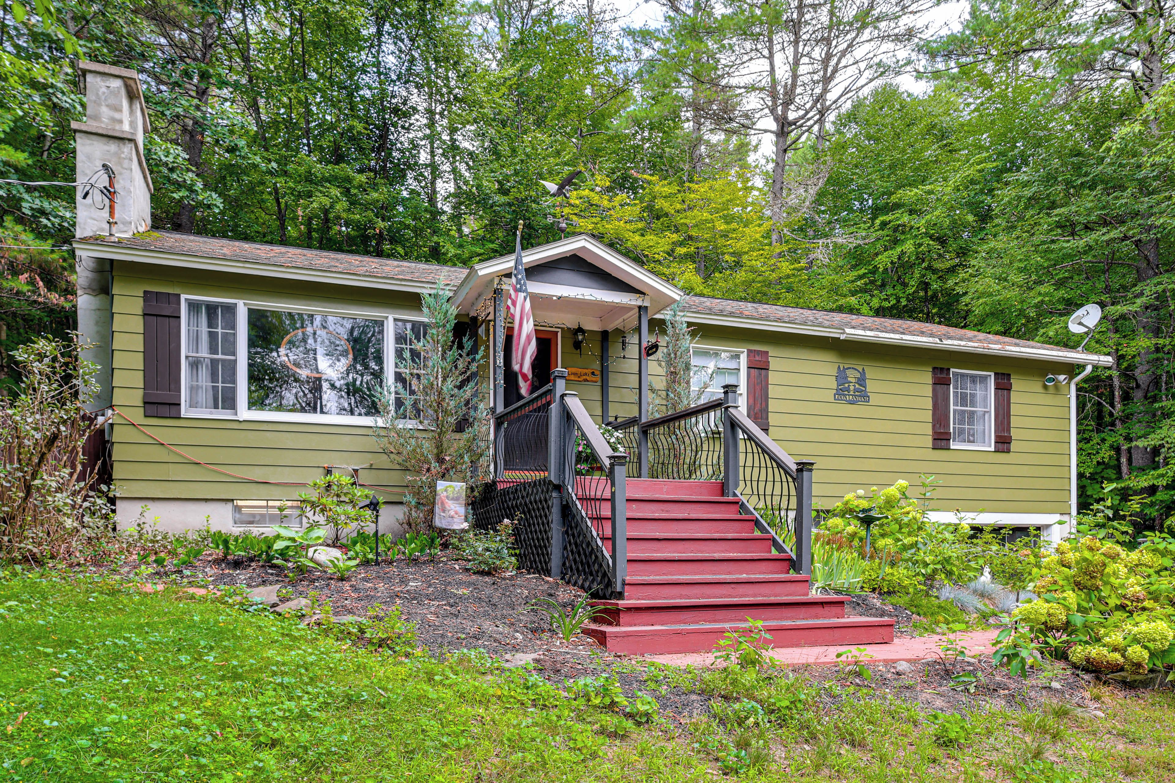 A two-story house with a red staircase, a front porch, and a satellite dish.