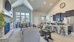 A spacious living area with a fireplace, a large sofa, and a dining table. - Elegant Loveland Condo < 5 Mi to Old Town! (Loveland)