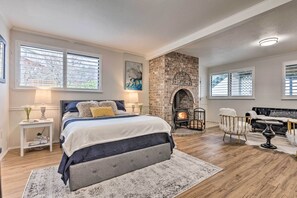 A bedroom with a large bed, a fireplace, and a seating area with a sofa and armchair. - PNW Retreat Fireplace Seattle Views (Port Orchard)