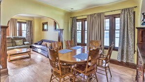 A dining area with a wooden table and chairs, a sofa, and a window with curtains. - Lovely Milwaukee Getaway - Family Friendly! (Milwaukee)