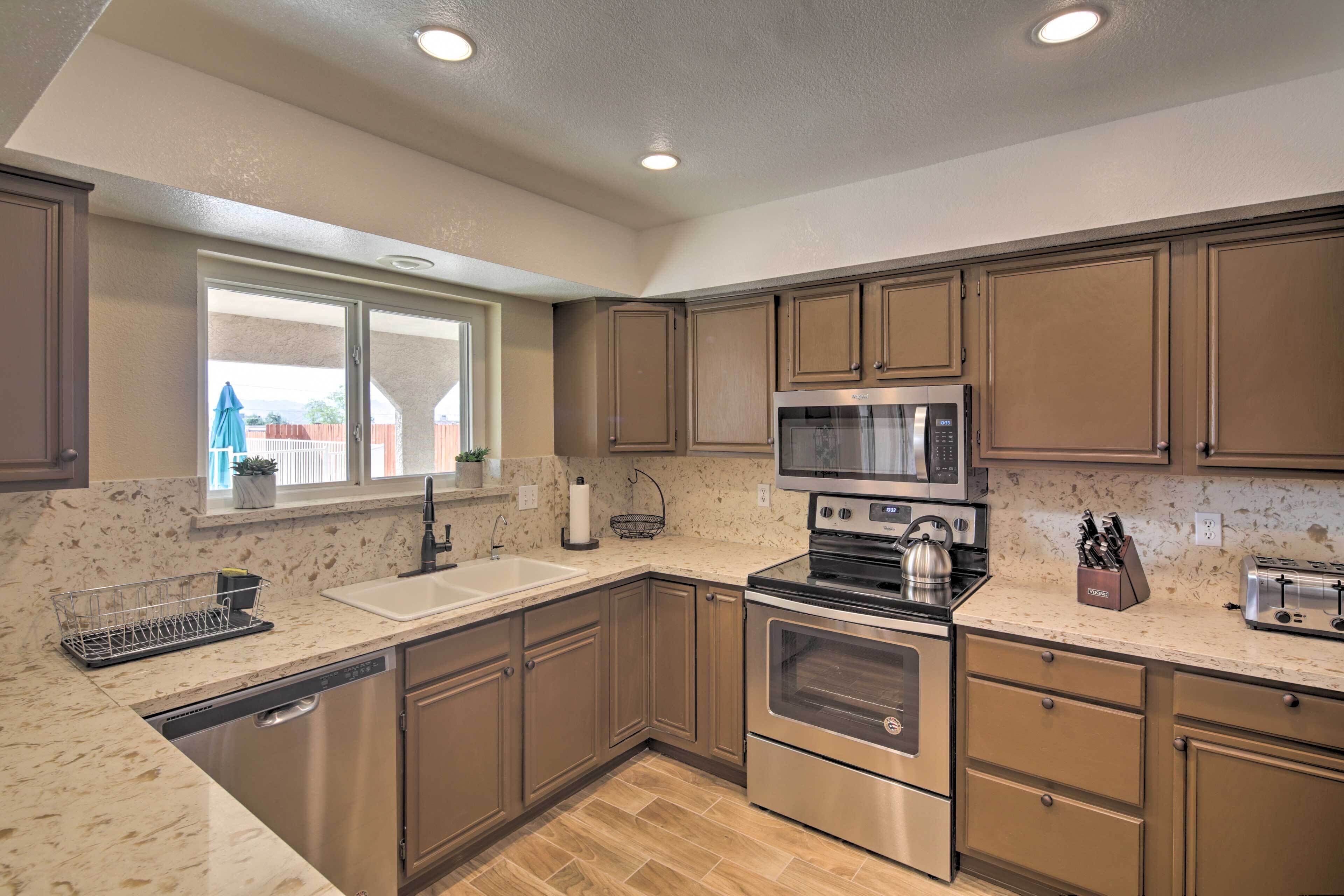 A modern kitchen with stainless steel appliances, a dishwasher, and a window providing natural light.