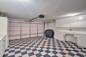 A garage with a checkered floor, a ceiling-mounted projector, and a covered object. - < 3 Mi to Lake Havasu: Home w/ Patio & Grill! (Lake Havasu City)