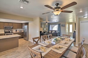 A modern kitchen with a central island, built-in appliances, and a dining area with a large table set for six. - < 3 Mi to Lake Havasu: Home w/ Patio & Grill! (Lake Havasu City)