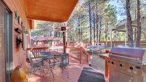 A wooden deck with a grill and outdoor furniture.