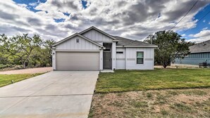 A single-story house with a garage, a front door, and a small front yard. - Modern Granite Shoals Retreat w/ Fire Pit! (Marble Falls)
