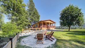Eine Lodge mit überdachter Veranda, Sitzgelegenheiten im Freien und einer Steinterrasse.