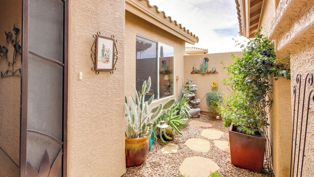 A courtyard with potted cacti and succulents, a stone pathway, and a building with a tiled roof. - Rustic Tucson Vacation Rental w/ Pool & Spa! (Saddlebrooke)