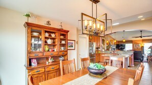 A spacious kitchen with wooden cabinets, a central island, and a dining area with a large wooden table. - Rustic Tucson Vacation Rental w/ Pool & Spa! (Saddlebrooke)