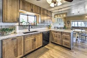 A modern kitchen with wooden cabinets, granite countertops, and a built-in dishwasher. - Hot Tub & Deck: Pet-friendly Home in Payson (Payson)