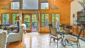 A spacious wooden cabin with a large dining area, multiple windows, and a cozy seating area. - Log Cabin in Payson w/ Deck, Mtn & Creek Views (Payson)