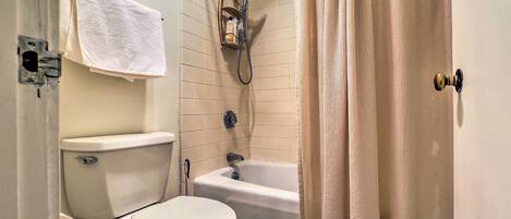 A bathroom with a toilet, sink, and bathtub.
