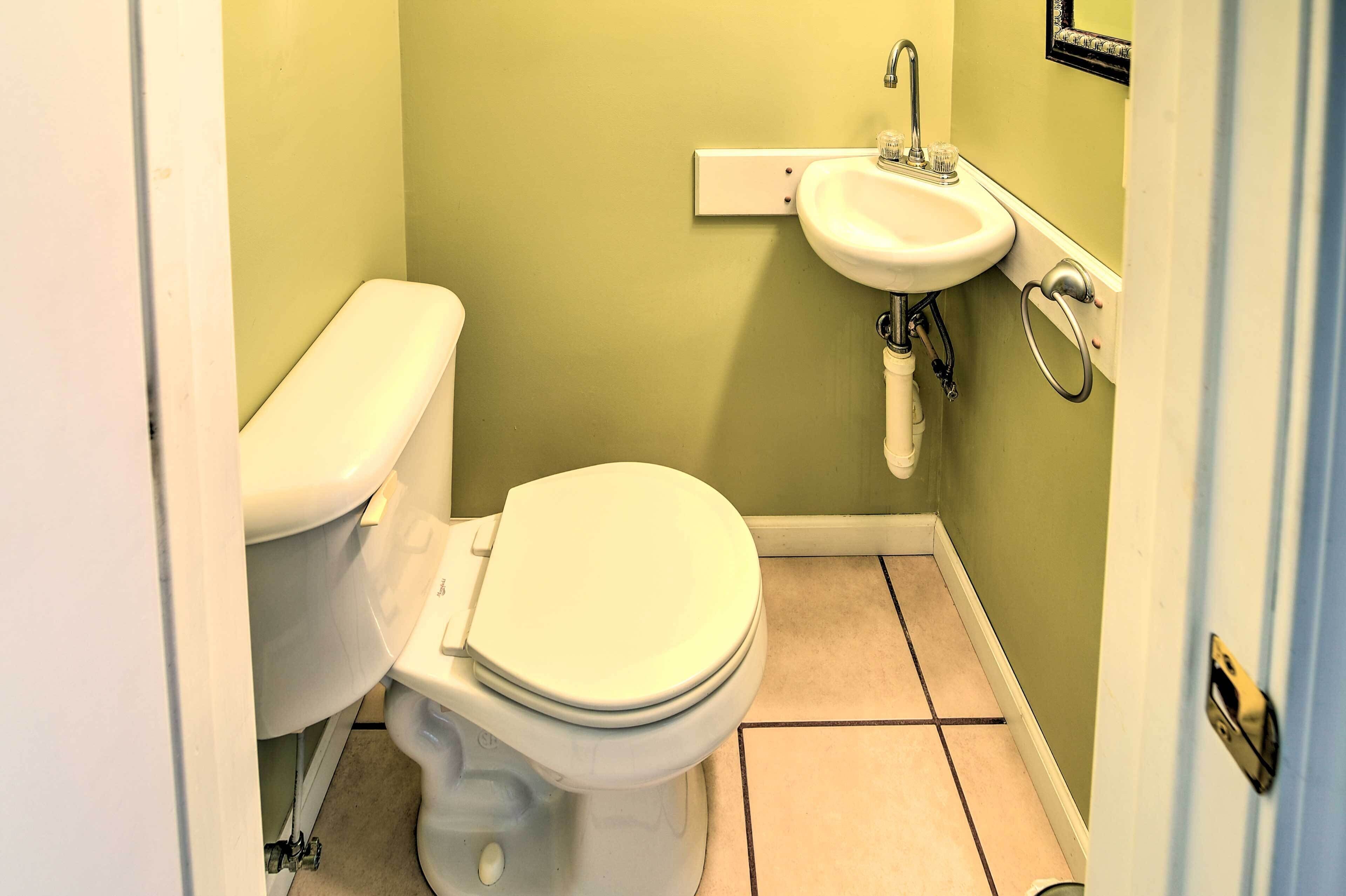 Un bagno piccolo con il water, un lavandino e pavimento piastrellato.