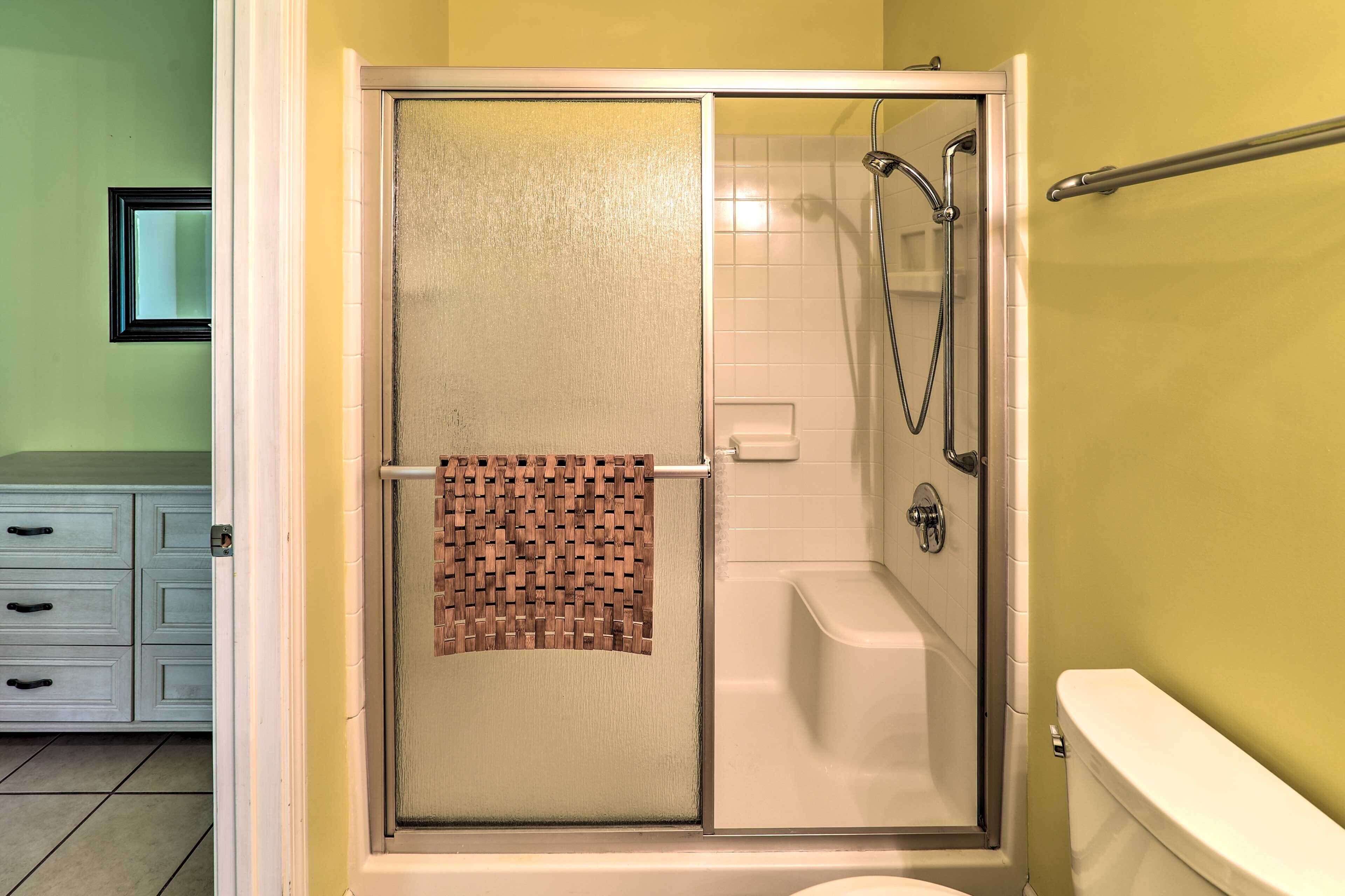 Un baño con ducha, inodoro y lavabo con espejo.
