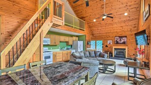 A spacious cabin interior with a dining area, kitchen, living room, and a fireplace. - Ohio River Views: Home w/ Fireplace & Deck! (Wolf Creek)