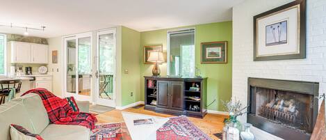 A living room with a fireplace, a sofa, a coffee table, and a rug.