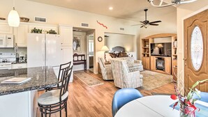 A modern kitchen with white cabinets, a granite countertop, and a dining area with a table and chairs. - Lovely Tucson Home w/ Private Pool & Hot Tub! (Tucson)