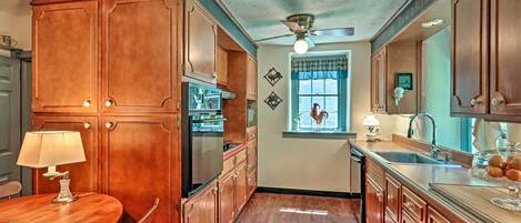 A kitchen with wooden cabinets, a dining table, and a ceiling fan.