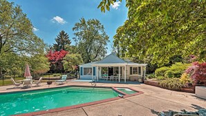 Un jardin avec une piscine, des chaises longues et un kiosque.