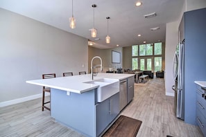 A modern kitchen with a central island, built-in appliances, and pendant lighting.