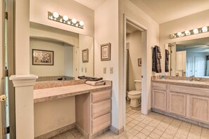 A bathroom with a vanity, a toilet, and a mirror with lights. - Michigan Condo: Heated Indoor Community Pool! (Pigeon)