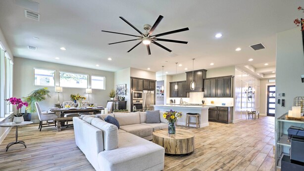 A spacious living area with a sectional sofa, a round coffee table, and a dining area with a table and chairs. - Upscale Austin Area Escape: Families Welcome! (Austin)
