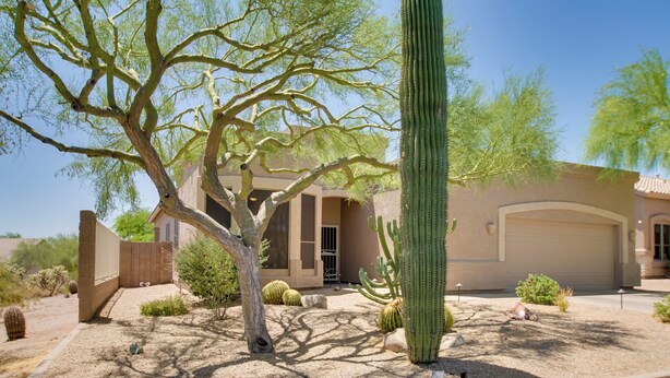 A desert landscape with a large cactus, a tree, and a building with a beige facade. - Walk to Trails: Mtn-view Mesa Getaway w/ Gril (Mesa)