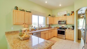 A kitchen with granite countertops, wooden cabinets, a microwave, stove, and a large window. - Walk to Trails: Mtn-view Mesa Getaway w/ Gril (Mesa)