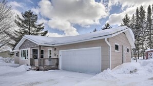 A single-story house with a garage, surrounded by snow-covered ground and trees. - Cozy White Pine Home - 10 Mi to Porcupine Mtn (White Pine)