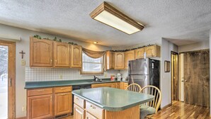 A kitchen with wooden cabinets, a central island, and a built-in refrigerator. - Cozy White Pine Home - 10 Mi to Porcupine Mtn (White Pine)
