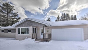 A single-story house with a garage, a covered porch, and a snow-covered driveway. - Cozy White Pine Home - 10 Mi to Porcupine Mtn (White Pine)