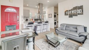 A modern living room with a grey sofa, a glass coffee table, and a red door. - 5 Mi to Universal Studios: Family Gem w/ Hot Tub! (Burbank)