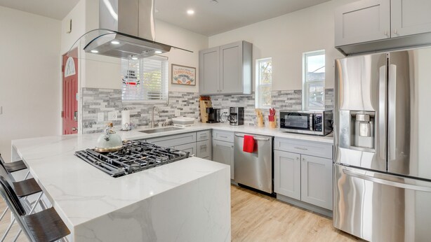 A modern kitchen with a central island, stainless steel appliances, and a tiled backsplash. - 5 Mi to Universal Studios: Family Gem w/ Hot Tub! (Burbank)