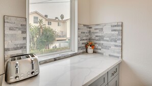 A kitchen with a built-in toaster, a window, and a backsplash with gray and white tiles. - 5 Mi to Universal Studios: Family Gem w/ Hot Tub! (Burbank)