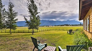 A patio with outdoor seating, a wooden fence, and a view of mountains. - Columbia Falls Home 19 Mi to Glacier National Park (Columbia Falls)