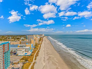 Un paisaje urbano costero con playa, edificios y cielo despejado.
