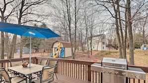 A deck with a grill, a table with chairs, and a blue umbrella. - Walk to Pool & Lake: Albrightsville Vacation Home! (Albrightsville)