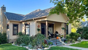 A single-story house with a front porch, a chimney, and a well-maintained garden. - Lovely Montrose Home w/ Yard: Walk to Dtwn & Park! (Montrose)