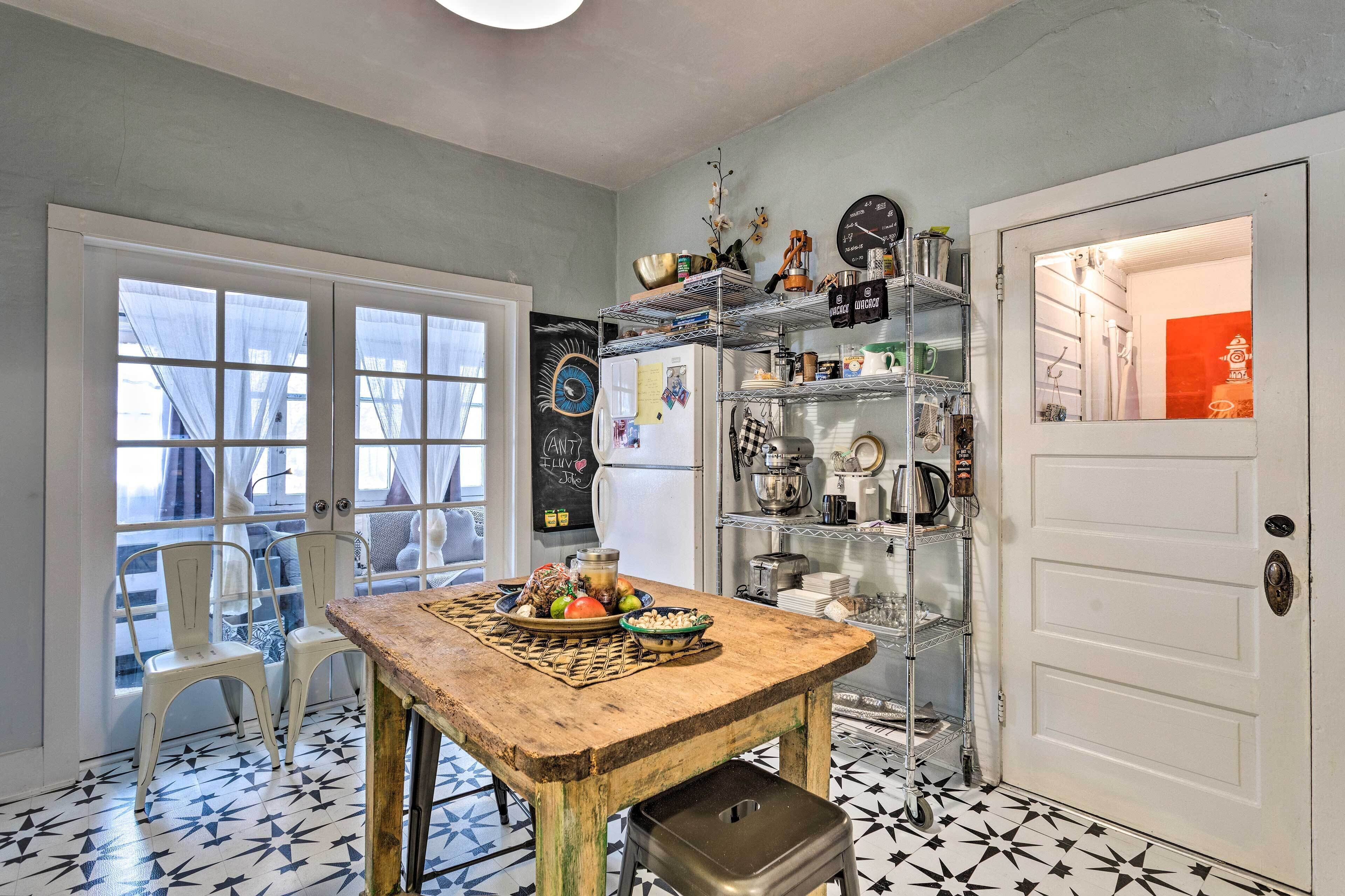 A kitchen with a wooden table, chairs, and a white door.