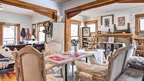 A cozy room with a wooden table, chairs, and a fireplace. There is a couch and a mirror on the wall. - Lovely Montrose Home w/ Yard: Walk to Dtwn & Park! (Montrose)