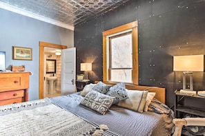 A bedroom with a large bed, two bedside tables, a window, and a ceiling with a geometric pattern. - Lovely Montrose Home w/ Yard: Walk to Dtwn & Park! (Montrose)