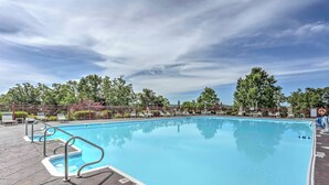 A swimming pool with a clear blue water surface, surrounded by a paved deck with lounge chairs and a fence. - Holiday Hills Resort Condo w/ Hot Tub Access (Branson)